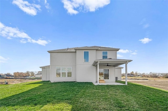 back of property with a yard, a patio, and ceiling fan