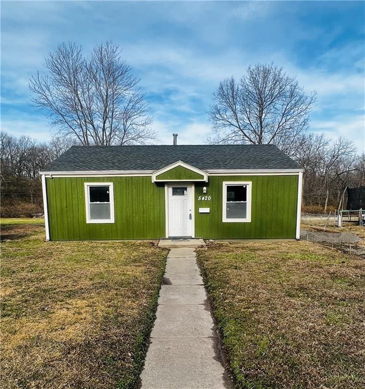 ranch-style house with a front yard and a trampoline