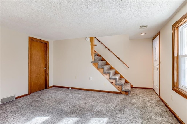 5032 NE 57th Ter, Kansas City, MO 64119 - unfurnished room with a textured ceiling, carpet floors, stairway, healthy amount of natural light, and baseboards