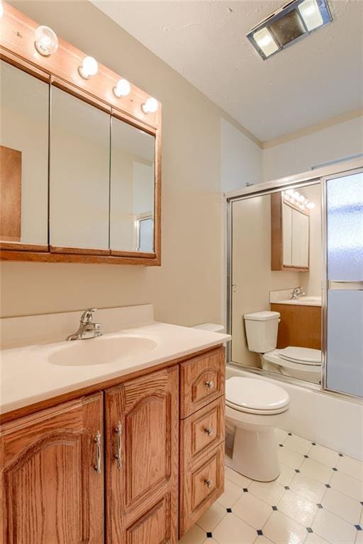 5032 NE 57th Ter, Kansas City, MO 64119 - full bath with vanity, toilet, bath / shower combo with glass door, and tile patterned floors