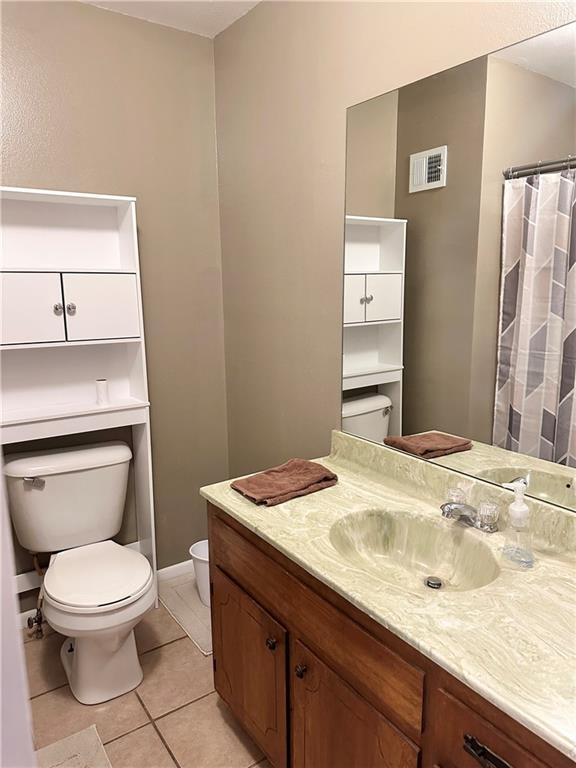 bathroom with tile patterned flooring, vanity, and toilet