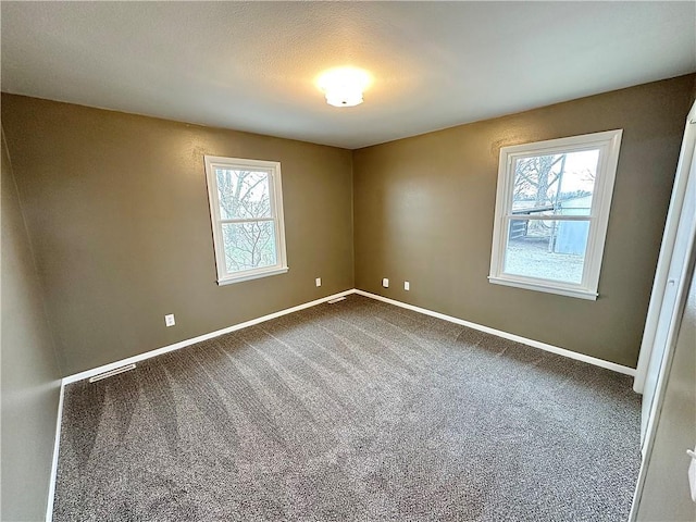 carpeted spare room featuring plenty of natural light