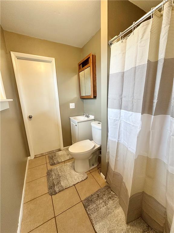 bathroom featuring tile patterned floors, a shower with curtain, vanity, and toilet