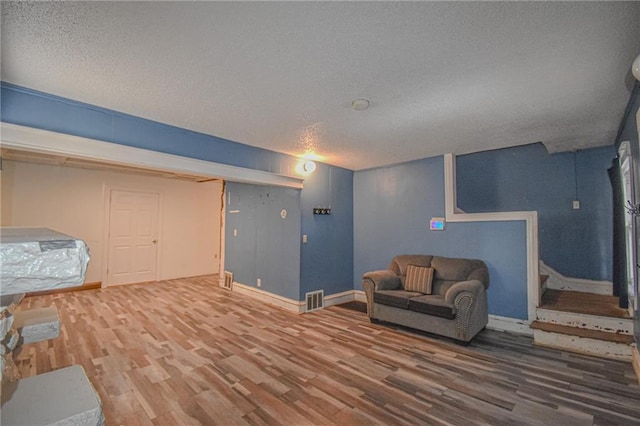 living area with wood-type flooring and a textured ceiling