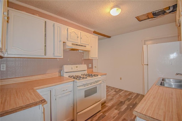 kitchen with white appliances, white cabinets, sink, a textured ceiling, and light hardwood / wood-style floors