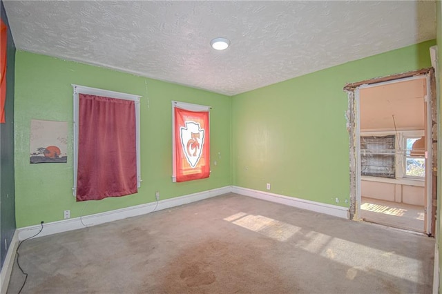 unfurnished room with carpet flooring and a textured ceiling