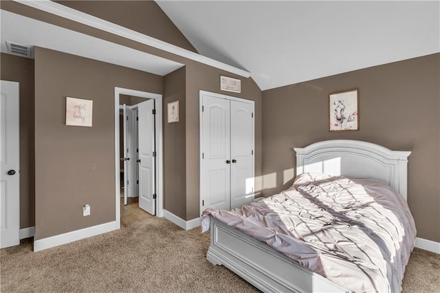 bedroom with light colored carpet, a closet, and lofted ceiling