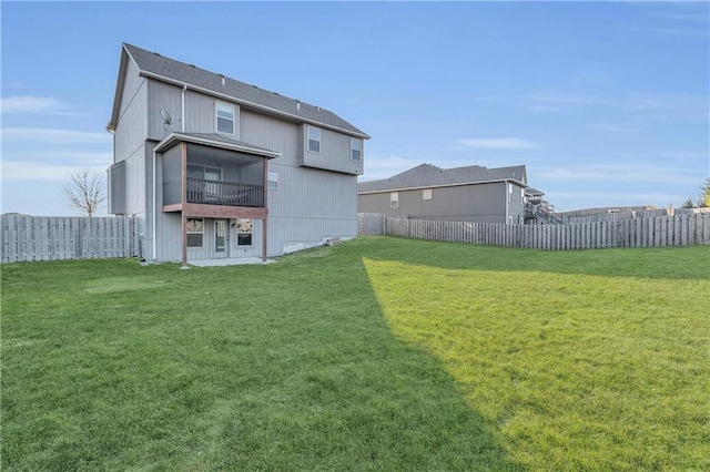 back of property featuring a sunroom and a lawn