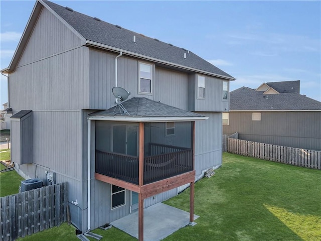 rear view of property featuring a sunroom, cooling unit, and a yard