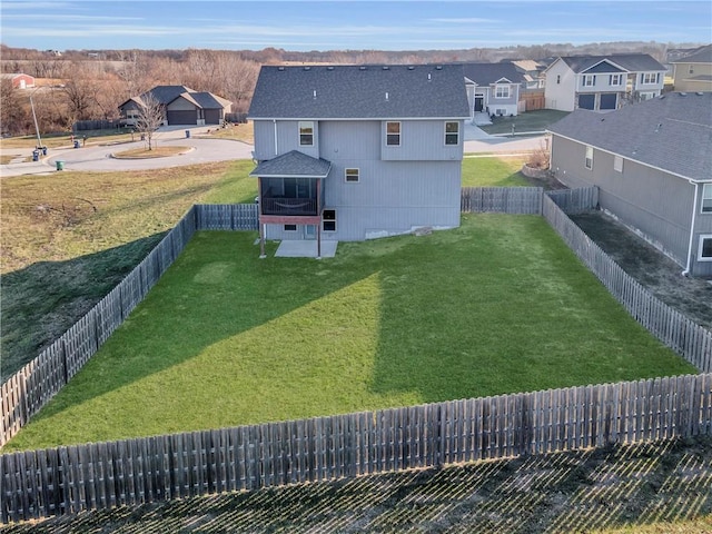 rear view of house featuring a yard and a sunroom