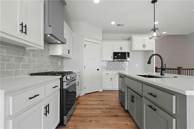 kitchen featuring appliances with stainless steel finishes, sink, gray cabinetry, and white cabinets