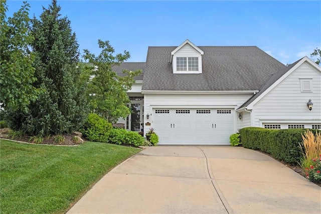 cape cod-style house featuring a front yard and a garage