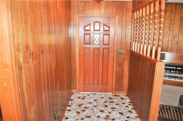 foyer entrance featuring wooden walls