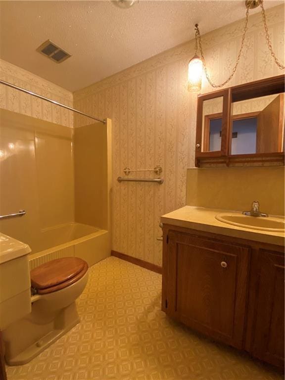 full bathroom with a textured ceiling, vanity, toilet, and shower / washtub combination