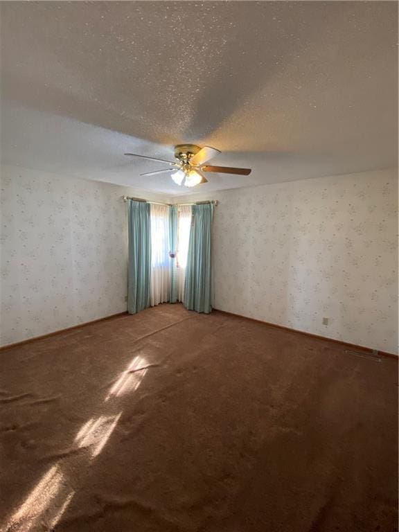 empty room featuring ceiling fan, carpet floors, and a textured ceiling