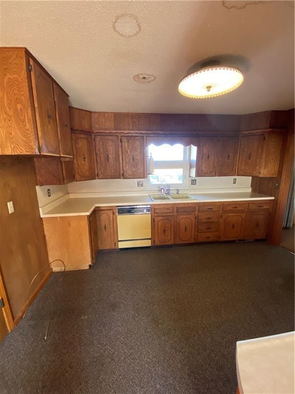 kitchen with sink, white dishwasher, and a textured ceiling