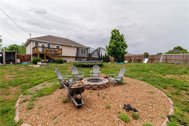 1702 Arrowhead Dr, Atchison, KS 66002 - view of yard featuring a trampoline, an outdoor fire pit, stairs, a wooden deck, and a playground