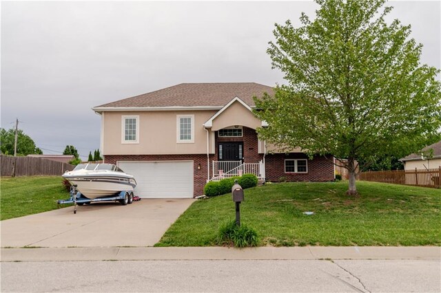 1702 Arrowhead Dr, Atchison, KS 66002 - split foyer home featuring a garage, driveway, brick siding, and stucco siding