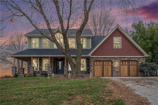 view of front of home with a garage and a yard