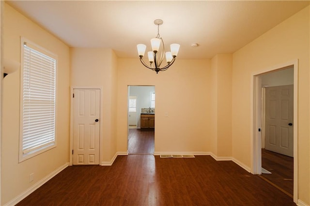 unfurnished dining area featuring a notable chandelier, dark hardwood / wood-style flooring, and sink