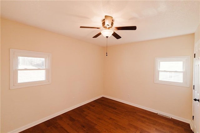 spare room with dark hardwood / wood-style flooring and ceiling fan