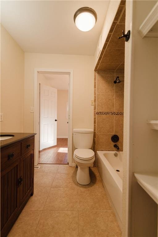 full bathroom with tile patterned floors, vanity, tiled shower / bath combo, and toilet