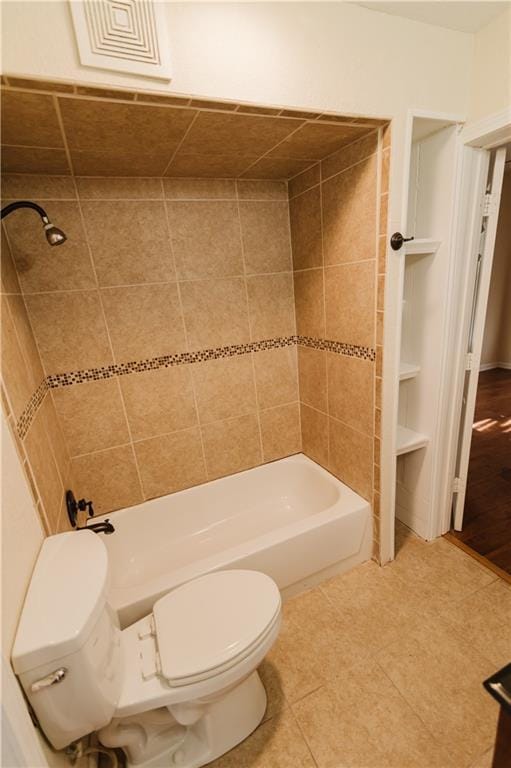 bathroom featuring tile patterned floors, tiled shower / bath combo, and toilet