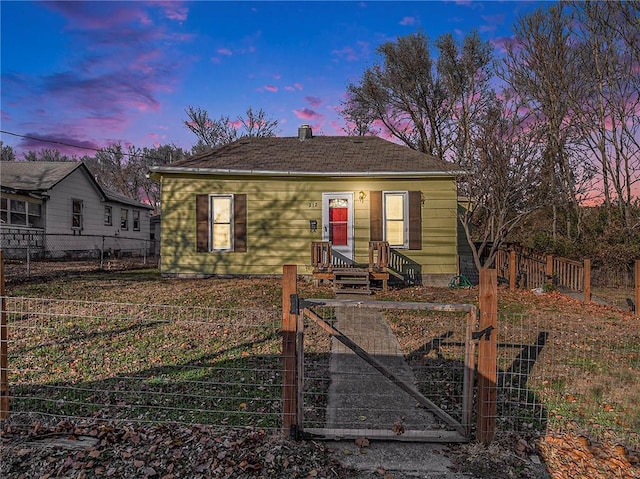 bungalow with a fenced front yard, a chimney, and a gate