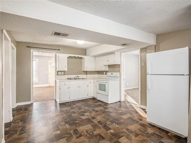 kitchen featuring white appliances, baseboards, light countertops, white cabinetry, and a sink