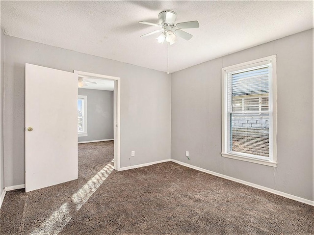 carpeted spare room with a ceiling fan, a textured ceiling, and baseboards