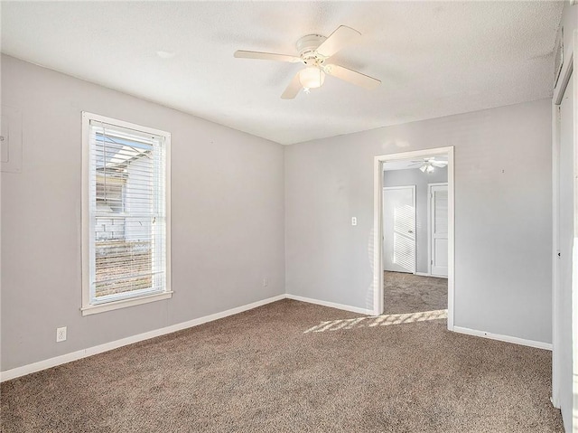 unfurnished room featuring a ceiling fan, carpet flooring, and baseboards