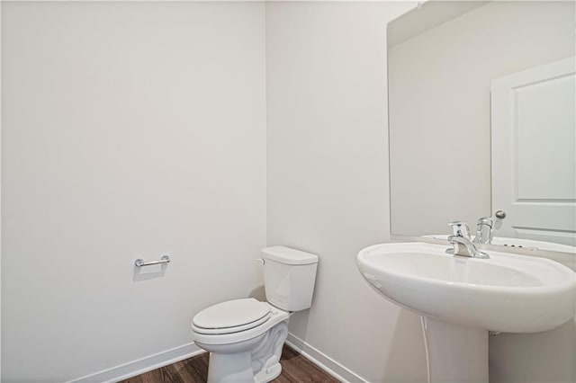 bathroom featuring wood-type flooring and toilet