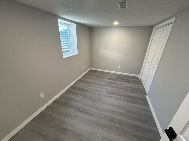 basement with a textured ceiling and dark hardwood / wood-style floors