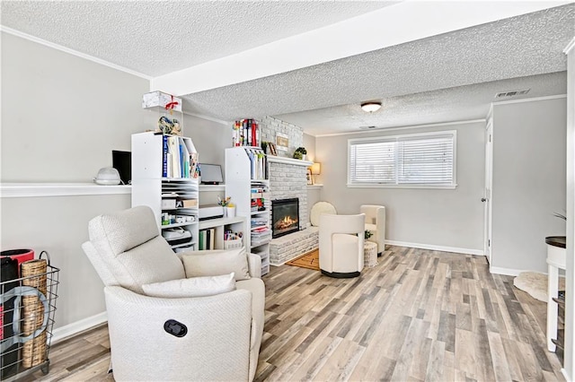 living room with a fireplace, a textured ceiling, and light hardwood / wood-style flooring