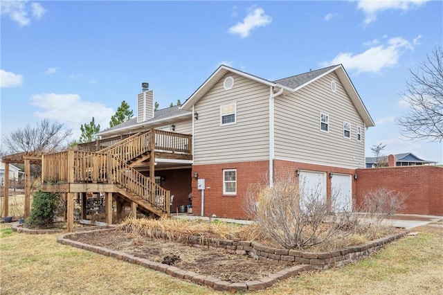 rear view of property featuring a garage and a wooden deck