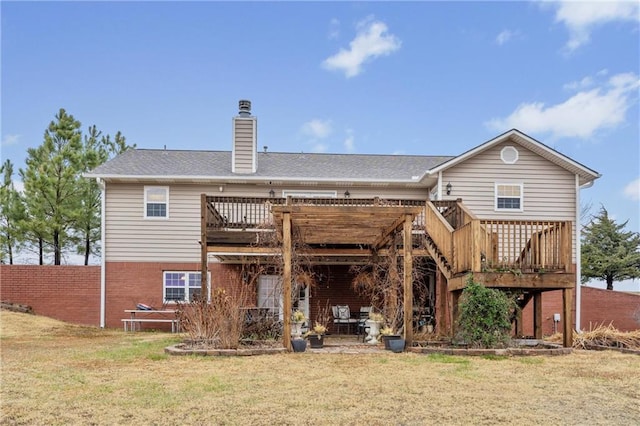 rear view of house with a wooden deck and a yard