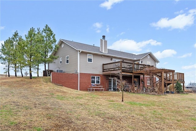 rear view of house with a lawn and a wooden deck