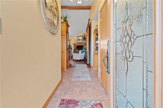 hallway featuring light tile patterned floors and lofted ceiling