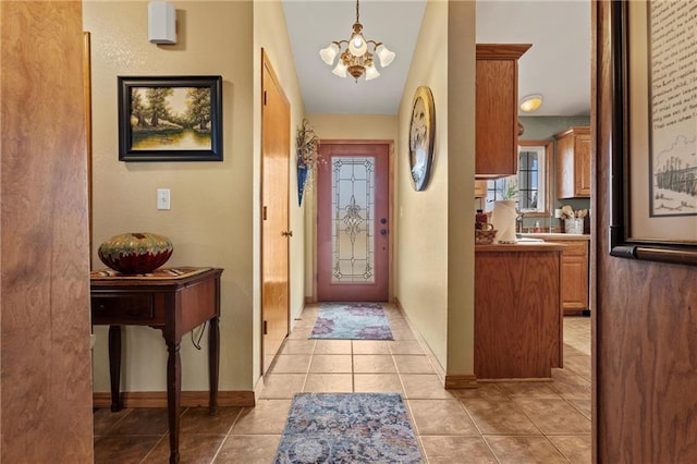 foyer featuring an inviting chandelier, light tile patterned flooring, and vaulted ceiling