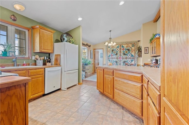 kitchen with white appliances, an inviting chandelier, hanging light fixtures, lofted ceiling, and light tile patterned flooring