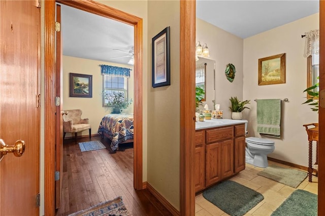 bathroom with hardwood / wood-style flooring, plenty of natural light, toilet, and vanity