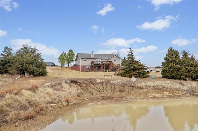 rear view of property featuring a deck with water view