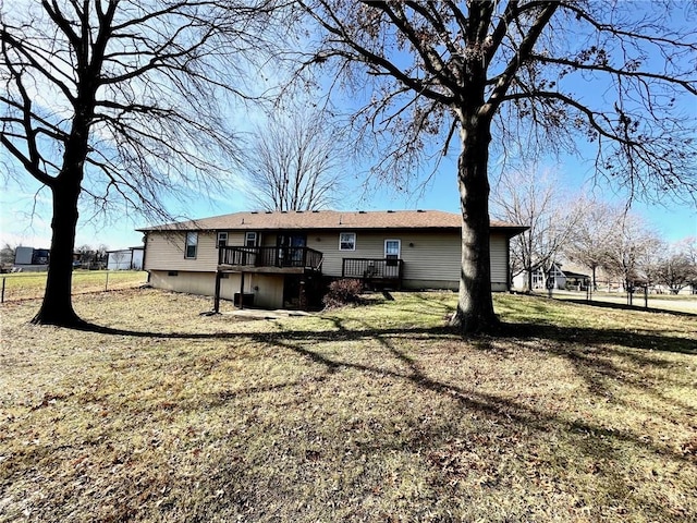 rear view of property with a lawn and a deck