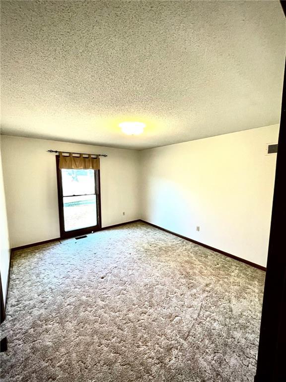 empty room featuring a textured ceiling and carpet floors