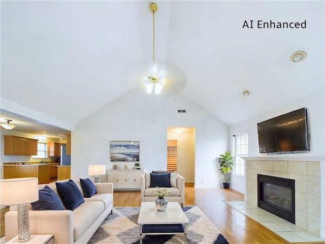 living room with a fireplace, high vaulted ceiling, and light wood-type flooring