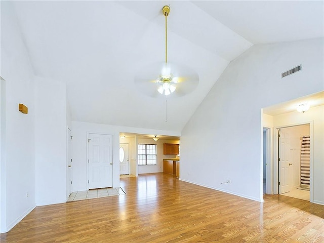 unfurnished living room featuring ceiling fan, high vaulted ceiling, and light hardwood / wood-style flooring