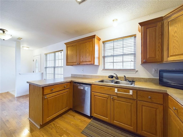 kitchen with a wealth of natural light, dishwasher, kitchen peninsula, and light wood-type flooring