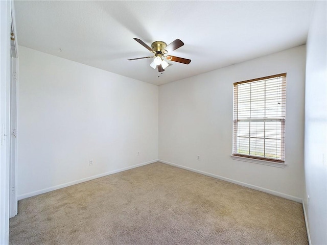 carpeted spare room featuring ceiling fan