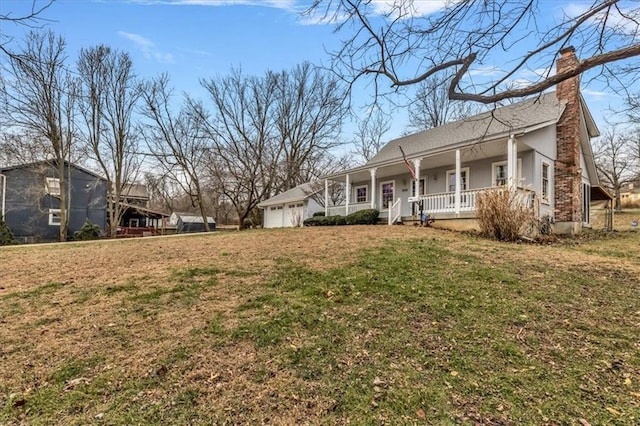 exterior space featuring covered porch, a garage, and a front lawn