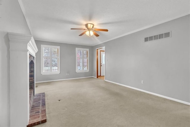 unfurnished living room with light carpet, crown molding, a brick fireplace, ceiling fan, and a textured ceiling